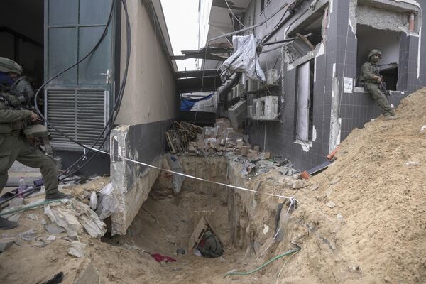 سربازان اسرائیلی روز چهارشنبه 22 نوامبر 2023 یک تونل زیرزمینی پیدا شده در زیر بیمارستان شفا در شهر غزه را به رسانه ها نشان دادند. اسرائیل می گوید که شبه نظامیان حماس در محوطه بیمارستان به دنبال پوشش بودند و از تونل برای اهداف نظامی استفاده کردند. (AP Photo/Victor R. Caivano) - اسپوتنیک ایران  
