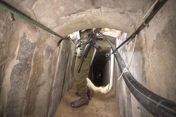 چهارشنبه، 22 نوامبر 2023، یک سرباز اسرائیلی در یک تونل زیرزمینی در زیر بیمارستان شفا در شهر غزه ایستاده است. اسرائیل می گوید که شبه نظامیان حماس در محوطه بیمارستان به دنبال پوشش بودند و از تونل برای اهداف نظامی استفاده کردند. (AP Photo/Victor R. Caivano) - اسپوتنیک ایران  