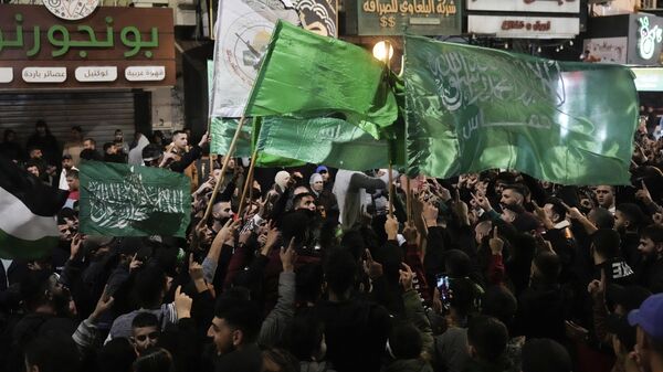 Палестинцы машут флагами ХАМАС, празднуя освобождение Израилем палестинских заключенных в городе Наблус на Западном Берегу - اسپوتنیک ایران  