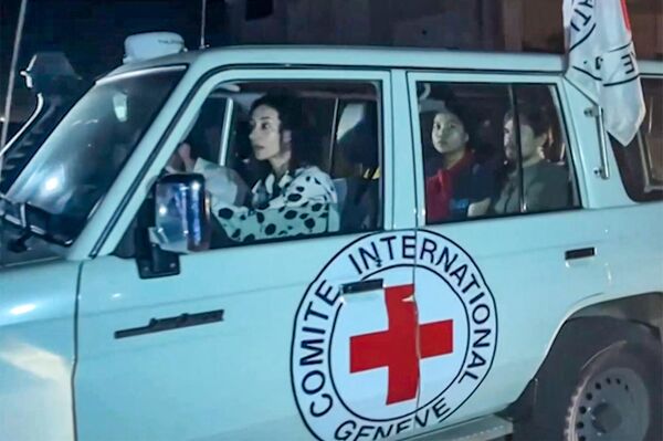 این تصویر که از یک فیلم ویدئویی AFPTV گرفته شده است نشان می‌دهد که یک خودروی صلیب سرخ بین‌المللی حامل گروگان‌های آزاد شده توسط حماس از نقطه مرزی رفح در نوار غزه به سمت مصر عبور می‌کند و از آنجا به اسرائیل منتقل می‌شود تا در 24 نوامبر به خانواده‌هایشان ملحق شوند. 2023. هر دو طرف گفتند که پس از 48 روز تیراندازی و بمباران که هزاران نفر را گرفت، اولین گروگان‌هایی که بر اساس توافق آتش‌بس بین اسرائیل و حماس آزاد شدند، در 24 نوامبر تحویل داده شدند، تقریباً هفت هفته پس از دستگیری. (عکس از محمود حمص / AFPTV / AFP) - اسپوتنیک ایران  