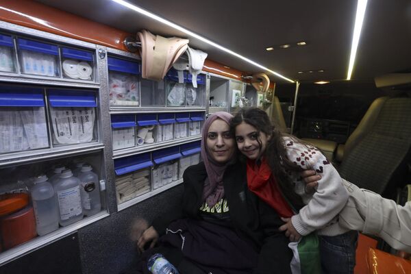 فاطمه شاهین که قادر به راه رفتن نیست، دخترش آیلول را در حالی که پس از آزادی از زندان اسرائیل در داخل آمبولانس نشسته، به عنوان بخشی از توافق آتش بس بین اسرائیل و حماس در اردوگاه آوارگان الدحیشه در کرانه باختری اشغالی بیت لحم، در 24 نوامبر 2023 در آغوش می گیرد. هر دو طرف گفتند که پس از 48 روز تیراندازی و بمباران که هزاران کشته بر جای گذاشت، اولین گروگان‌هایی که بر اساس توافق آتش‌بس بین اسرائیل و حماس آزاد شدند، در 24 نوامبر تحویل داده شدند، تقریباً هفت هفته پس از دستگیری. (عکس از حازم بادر / خبرگزاری فرانسه) - اسپوتنیک ایران  