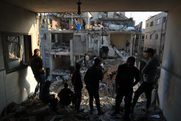 فلسطینی ها خرابی های  اطراف ساختمان های مسکونی را در پی حملات هوایی اسرائیل در اردوگاه آوارگان رفح در جنوب نوار غزه در 1 دسامبر 2023 بازرسی می کنند، زیرا درگیری ها اندکی پس از پایان آتش بس هفت روزه بین اسرائیل و شبه نظامیان حماس از سر گرفته شده است.آتش بس موقت بین اسرائیل و حماس در اول دسامبر منقضی شد و ارتش اسرائیل اعلام کرد که عملیات جنگی از سر گرفته شده است و حماس را به نقض آتش بس متهم کرد. - اسپوتنیک ایران  