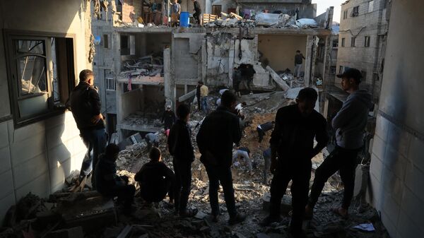 Палестинцы осматривают разрушения вокруг жилых зданий после авиаударов Израиля по лагерю беженцев Рафах  - اسپوتنیک ایران  