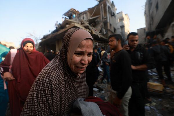 یک زن فلسطینی در حالی که مردم آوارهای ساختمانی را که در حمله هوایی اسرائیل به اردوگاه آوارگان رفح در جنوب نوار غزه در 1 دسامبر 2023 پس از پایان آتش بس هفت روزه بین اسرائیل و شبه نظامیان حماس ویران شده ، بررسی می کنند. آتش بس موقت هفت روزه بین اسرائیل و حماس در اول دسامبر منقضی شد و ارتش اسرائیل اعلام کرد که عملیات جنگی از سر گرفته شده و حماس را به نقض آتش بس متهم کرد. - اسپوتنیک ایران  