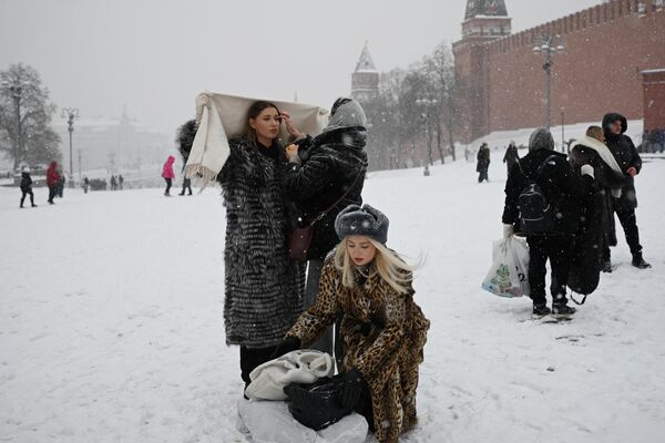دختری برای گرفتن عکس در میدان سرخ برفپوش آماده می شود. - اسپوتنیک ایران  