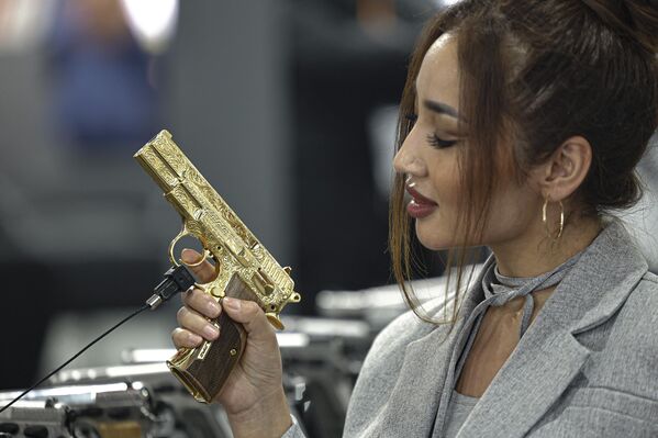 بازدیدکننده ای از قزاقستان در روز افتتاحیه سومین دوره نمایشگاه دفاعی مصر (ایدکس-2023)، با حضور 111 کشور شرکت کننده، در مرکز نمایشگاه های بین المللی قاهره، درمصر، یک اسلحه را آزمایش می کند. - اسپوتنیک ایران  