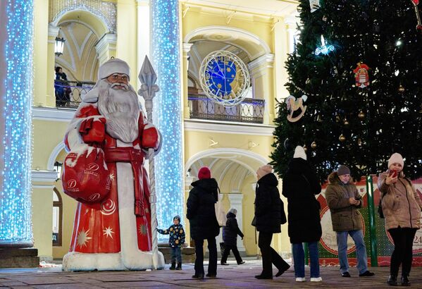 مردم در مقابل &quot;بابا نوئل&quot;  در &quot;محوطه مهمانسرای بزرگ&quot; در سن پترزبورگ عکس می گیرند. - اسپوتنیک ایران  