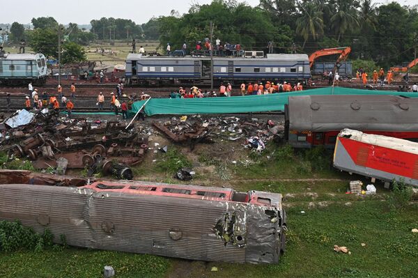 کارگران راه‌آهن به بازیابی خدمات در محل حادثه تصادف سه قطار در نزدیکی بالاسوره، حدود 200 کیلومتر (125 مایل) از مرکز ایالت بوبانسوار در ایالت شرقی اودیشا، در 4 ژوئن 2023 کمک می‌کنند. - اسپوتنیک ایران  