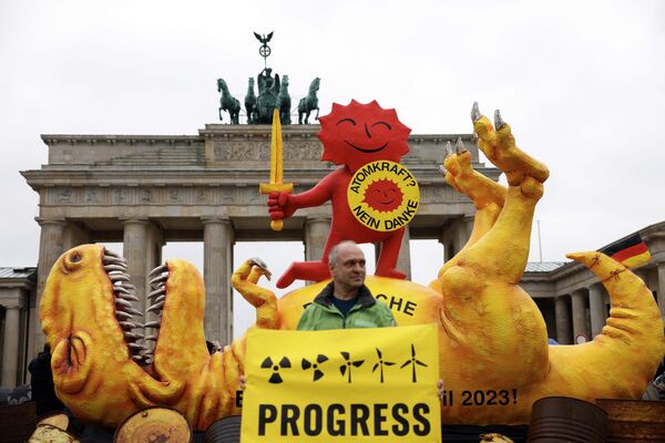 یکی از فعالان سازمان محیط زیست صلح سبز با پلاکاردی با مضمون &quot;پیشرفت&quot; در جریان تظاهراتی در مقابل دروازه شاخص براندنبورگ پایتخت در برلین در 15 آوریل 2023. - اسپوتنیک ایران  