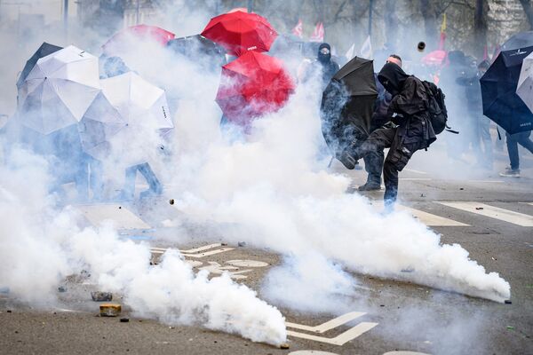 یک معترض در حین درگیری با پلیس ضدشورش در حاشیه تظاهرات در یازدهمین روز از اقدام اعتراضی، پس از آنکه دولت اصلاحات حقوق بازنشستگی را بدون رای گیری در پارلمان با استفاده از ماده 49.3 قانون اساسی در نانت، غرب فرانسه به اجرا گذاشت، گاز اشک آور را به عقب پرتاب کرد.  6 آوریل 2023، فرانسه. - اسپوتنیک ایران  