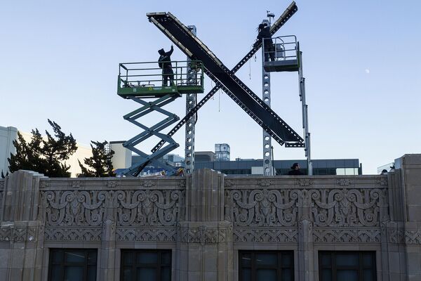 کارگران نورپردازی را بر روی تابلوی &quot;ایکس&quot; در بالای ساختمان مرکز شهر سانفرانسیسکو نصب می کنند که به طور رسمی به عنوان توییتر شناخته می شد و توسط مالک ایلان ماسک به ایکس تغییر نام داد، جمعه، 28 ژوئیه 2023. - اسپوتنیک ایران  