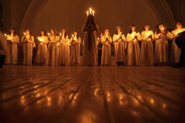 زنان و مردان جوان برای جشن گرفتن روز سنت لوسیا در کلیسای انجیلی لوتری سنت کاترین در سنت پترزبورگ، روسیه، در حالی که شمع در دست دارند، سرود می خوانند. چهارشنبه، 13 دسامبر 2023 - اسپوتنیک ایران  