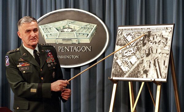 ژنرال هیو شلتون، رئیس ستاد مشترک ارتش ایالات متحده، در یک نشست خبری در 17 دسامبر در پنتاگون در واشنگتن دی سی، با استفاده از تصویر ماهواره ای برای نشان دادن آسیب وارد شده به مقر اطلاعات نظامی عراق در حمله موشکی 16 دسامبر  سخنرانی می کند.  - اسپوتنیک ایران  
