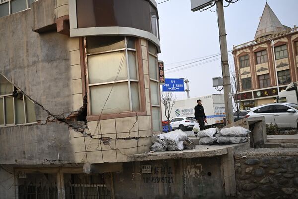 مردی در امتداد خیابانی پس از زلزله در  شهرستان جیشیشان در استان گانسو در شمال غربی چین در 19 دسامبر 2023 قدم می‌زند. - اسپوتنیک ایران  
