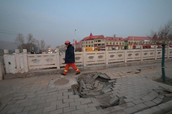 یک امدادگر در امتداد خیابانی پس از زلزله در داهجیا، شهرستان جیشیشان در استان گانسو شمال غربی چین در 19 دسامبر 2023 قدم می زند. - اسپوتنیک ایران  
