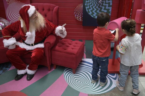 بچه ها نامه های خود برای بابانوئل را در صندوق پستی می اندازند. بوینس آیرس. - اسپوتنیک ایران  