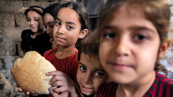 Дети с буханкой свежеиспеченного в глиняной печи хлеба в доме в Хан-Юнисе на юге сектора Газа - اسپوتنیک ایران  