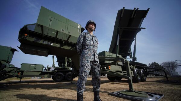 In this Jan. 18, 2018, file photo, a member of the Japan Ground Self-Defense Force stands guard next to a surface-to-air Patriot Advanced Capability-3 (PAC-3) missile interceptor launcher vehicle at Narashino Exercise Area in Funabashi, east of Tokyo.  - اسپوتنیک ایران  