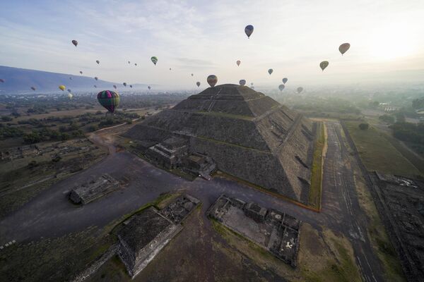 بالون‌ها با گردشگران بر فراز هرم خورشید در سایت باستان‌شناسی تئوتی‌هواکان، در شمال مکزیکوسیتی پرواز می‌کنند. - اسپوتنیک ایران  