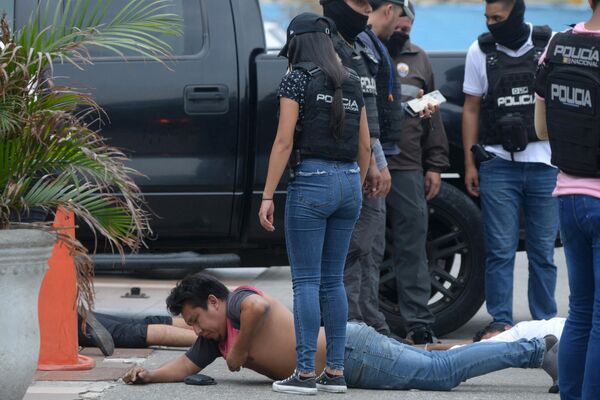 افسران پلیس اکوادور از مظنونان دستگیر شده در خارج از کانال تلویزیونی TC اکوادور پس از حمله افراد مسلح ناشناس به استودیوی تلویزیون دولتی به طور زنده در آنتن مراقبت می کنند.  - اسپوتنیک ایران  