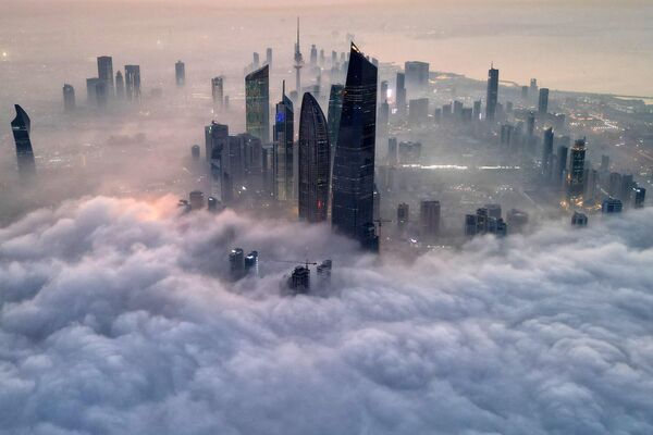 ابرها از میان آسمان خراش ها بر فراز  شهر کویت می گذرند. 10 دسامبر 2023 - اسپوتنیک ایران  
