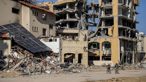 Палестинцы едут на велосипедах мимо разрушенных зданий в городе Газа - اسپوتنیک ایران  