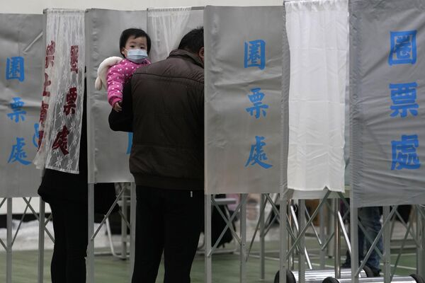 مردم در یک شعبه رای گیری در شهر تاینان در جنوب تایوان در انتخابات ریاست جمهوری شرکت می کنند.  - اسپوتنیک ایران  