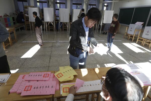 مردم تایوان رای خود را در یک شعبه رای در تایپه، تایوان به صندوق انداختند. - اسپوتنیک ایران  