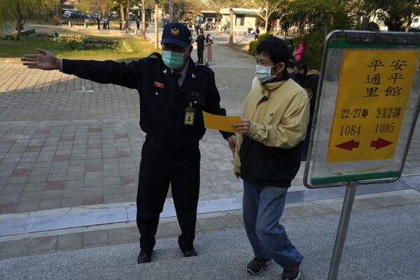 یک رای دهنده در یک شعبه رای گیری برای انتخابات ریاست جمهوری در شهر تاینان در جنوب تایوان راهنمایی می شود. - اسپوتنیک ایران  