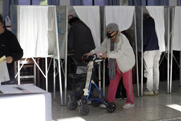 بیرون آمدن یک زن از یک صندوق رأی در یک شعبه رأی گیری در تایپه، تایوان. - اسپوتنیک ایران  
