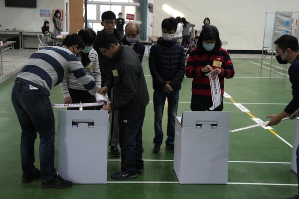 مقامات قبل از رای دادن در یک شعبه رای گیری برای انتخابات ریاست جمهوری در شهر تاینان در جنوب تایوان، صندوق های رای را چک می کنند. - اسپوتنیک ایران  
