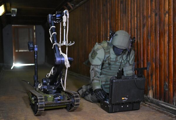 یک سرباز از نیروهای مهندسی نیروهای مسلح روسیه در حال نمایش مجتمع مین روبی روباتیک «کبرا» در منطقه مسکو. - اسپوتنیک ایران  