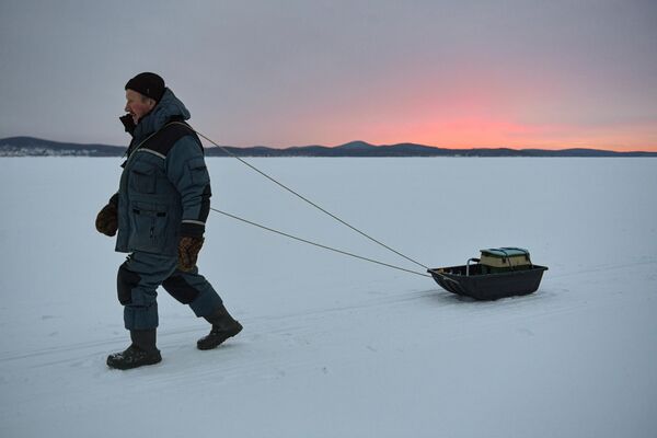 یک ماهیگیر در دریاچه یخ بسته تاواتوی در استان سوردلوفسک روسیه - اسپوتنیک ایران  