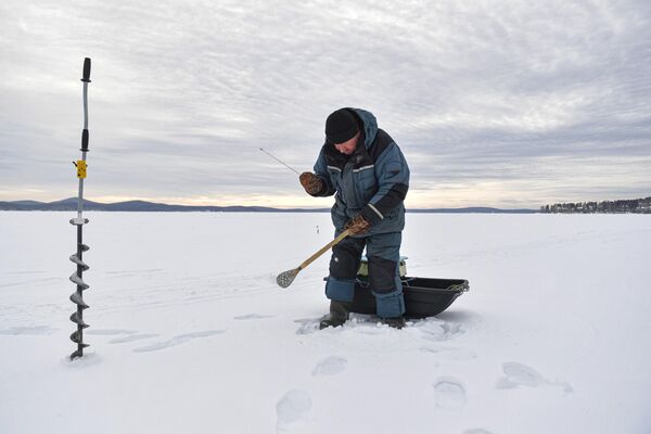 یک ماهیگیر در دریاچه یخ بسته تاواتوی در استان سوردلوفسک روسیه ماهی صید می کند. - اسپوتنیک ایران  