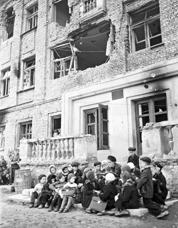جنگ بزرگ میهنی. 1941-1945 محاصره لنینگراد (8 سپتامبر 1941 - 27 ژانویه 1944). کلاس درس در کنار مدرسه ای که در اثر گلوله باران آلمان ها ویران شده است. - اسپوتنیک ایران  