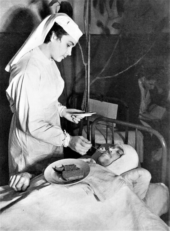 آنا یوشکویچ، پرستار بیمارستان نیروی دریایی در  لنینگراد، به یک ملوان  مجروح نیروی دریایی  شوروی غذا می دهد.  - اسپوتنیک ایران  