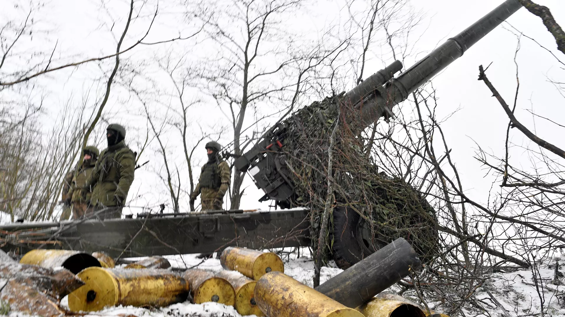 Russian artillerymen stand near a 2A65 Msta-B 152 mm towed howitzer at the firing position, as Russia's military operation in Ukraine continues, at unknown location.
