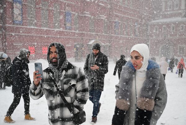 گردشگران هنگام بارش برف در مسکو در میدان سرخ قدم می زنند. سیکلون &quot;اولگا&quot; چنان بارش شدید برف را به مسکو آورد که می تواند رکوردشکن شود. امروز تا یک چهارم میزان عادی بارش برف در ماه  پیش بینی می شود که در یک روز بی سلبقه است. - اسپوتنیک ایران  