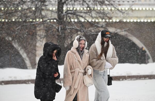 چند دختر در هنگام بارش برف در مسکو در باغ الکساندروف قدم می زنند. سیکلون &quot;اولگا&quot; چنان بارش شدید برف را به مسکو آورد که می تواند رکوردشکن شود. امروز تا یک چهارم میزان عادی بارش برف در ماه  پیش بینی می شود که در یک روز بی سلبقه است. - اسپوتنیک ایران  