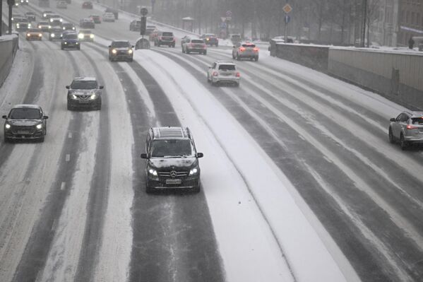 خودروها در خیابانی در مسکو هنگام بارش برف حرکت می کنند. سیکلون &quot;اولگا&quot; چنان بارش شدید برف را به مسکو آورد که می تواند رکوردشکن شود. امروز تا یک چهارم میزان عادی بارش برف در ماه  پیش بینی می شود که در یک روز بی سلبقه است. - اسپوتنیک ایران  