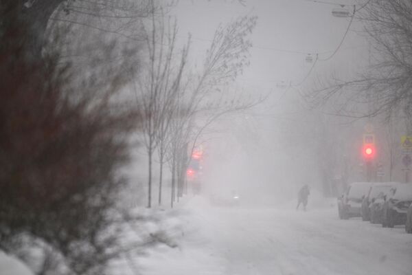 شخصی در 7 فوریه 2024 هنگام بارش برف شدید در مسکو از خیابانی عبور می کند. - اسپوتنیک ایران  
