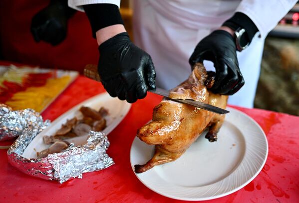 آشپزی در جشنواره سال نو چینی در مسکو   اردک کباب را با چاقو می برد . - اسپوتنیک ایران  