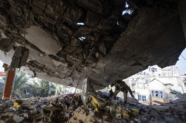 یک فلسطینی پس از حمله اسرائیل به رفح در حال جمع آوری وسایل باقی مانده در زیر آوار است.  - اسپوتنیک ایران  