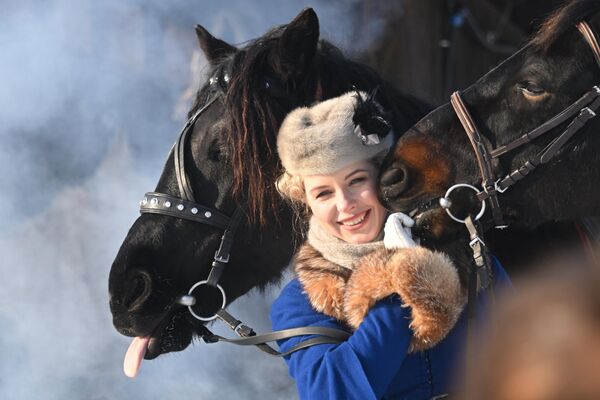 یک دختر، شرکت کننده در ورزشگاه اسب سواری شکار سگ &quot;آوان پست&quot;در کنار اسبهای زیبا در منطقه موژائیسک مسکو. - اسپوتنیک ایران  