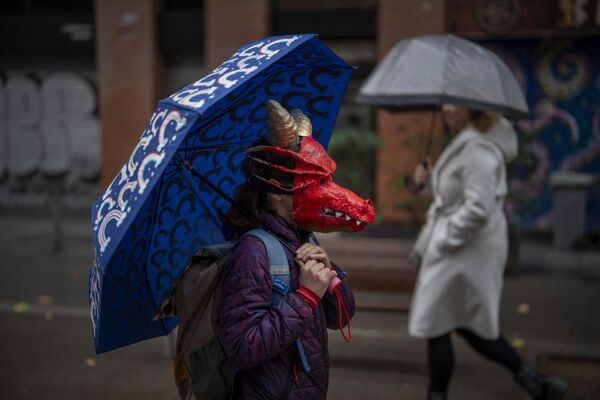 دختر با ماسک اژدها در راه مدرسه در بارسلون اسپانیا. - اسپوتنیک ایران  