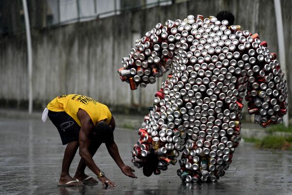 یک فرد محلی در مراسم رژه کارناوال مهمانی خیابانی «بلوکو دا لاتینها» در برزیل با لباسی که از قوطی های آبجو و نوشابه ساخته شده است. - اسپوتنیک ایران  