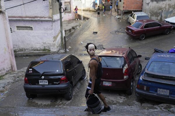 مرد و سطل در جریان برگزاری جشن های کارناوال در محله سان آگوستین در کاراکاس، ونزوئلا. - اسپوتنیک ایران  