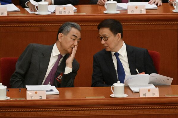 وزیر خارجه چین وانگ یی (سمت چپ) با معاون رئیس جمهور چین هان ژنگ در جلسه افتتاحیه کنگره ملی خلق (NPC) در تالار بزرگ مردم در پکن در 5 مارس 2024 صحبت می کند. - اسپوتنیک ایران  