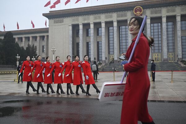 گروهی از حاضران در جلسه افتتاحیه کنگره ملی خلق (NPC) در پکن در 5 مارس در مقابل تالار بزرگ خلق عکس می گیرند. - اسپوتنیک ایران  