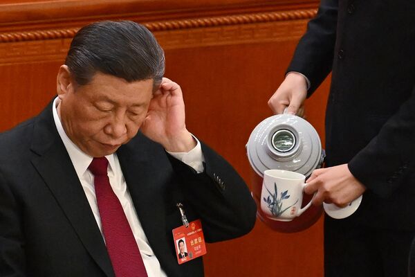 رهبر  چین، شی جین‌پینگ در حالی که یک خدمتکار در جلسه افتتاحیه کنگره ملی خلق (NPC) در تالار بزرگ مردم در پکن در 5 مارس 2024 یک فنجان چای را پر می‌کند. - اسپوتنیک ایران  